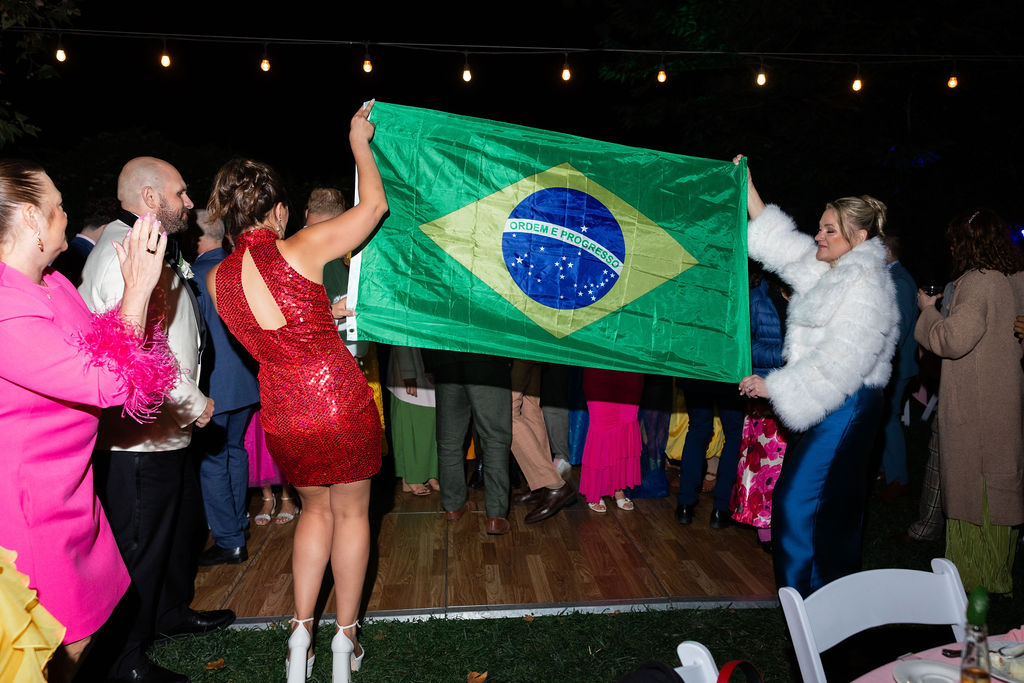 Bridesmaids hold up a brazil flag during a wedding reception dance party