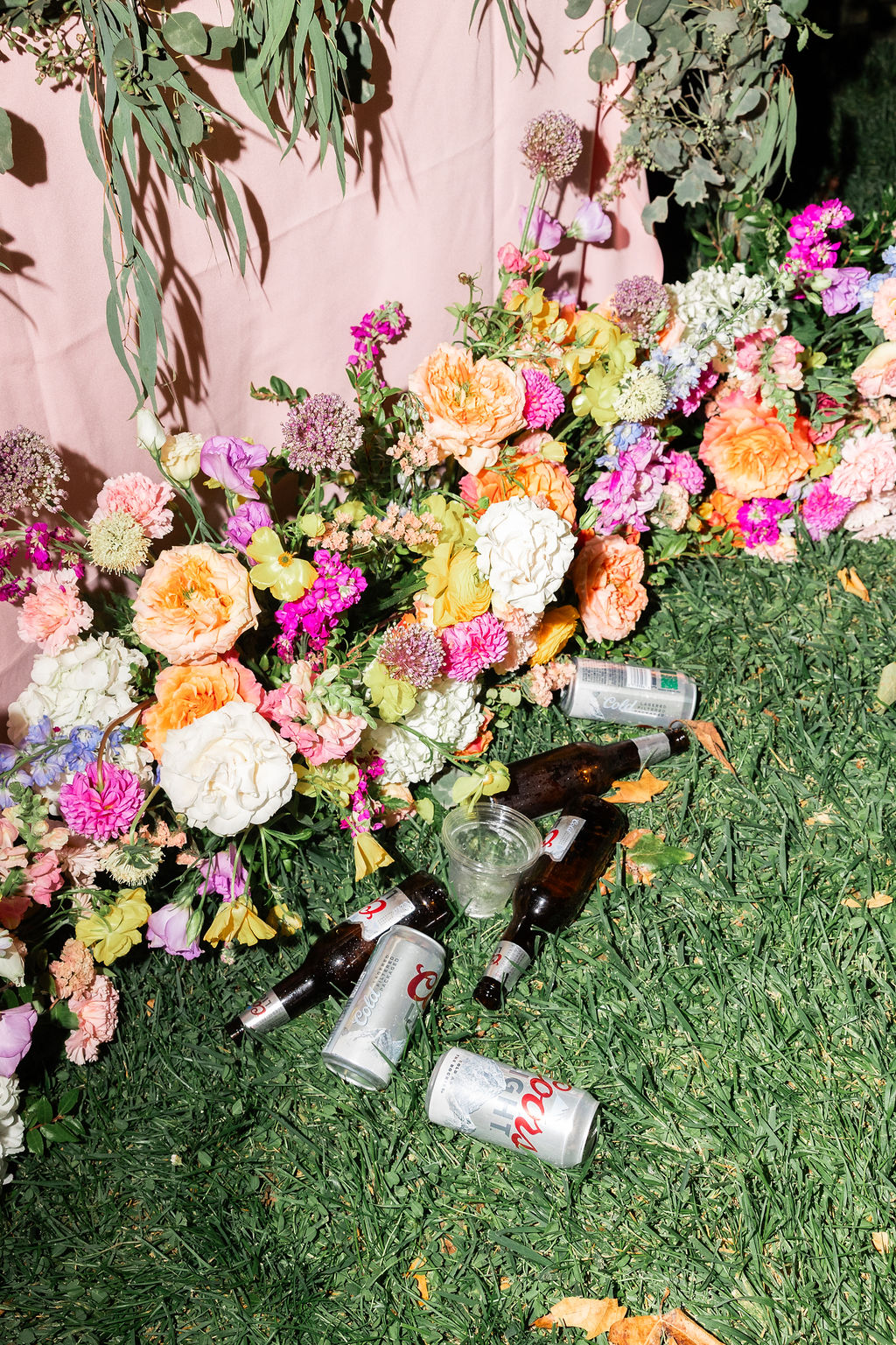 Details of flowers littered with coors light beer cans and bottles