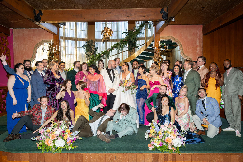 Newlyweds with their entire wedding party in a grand lobby at the Madonna Inn wedding venue