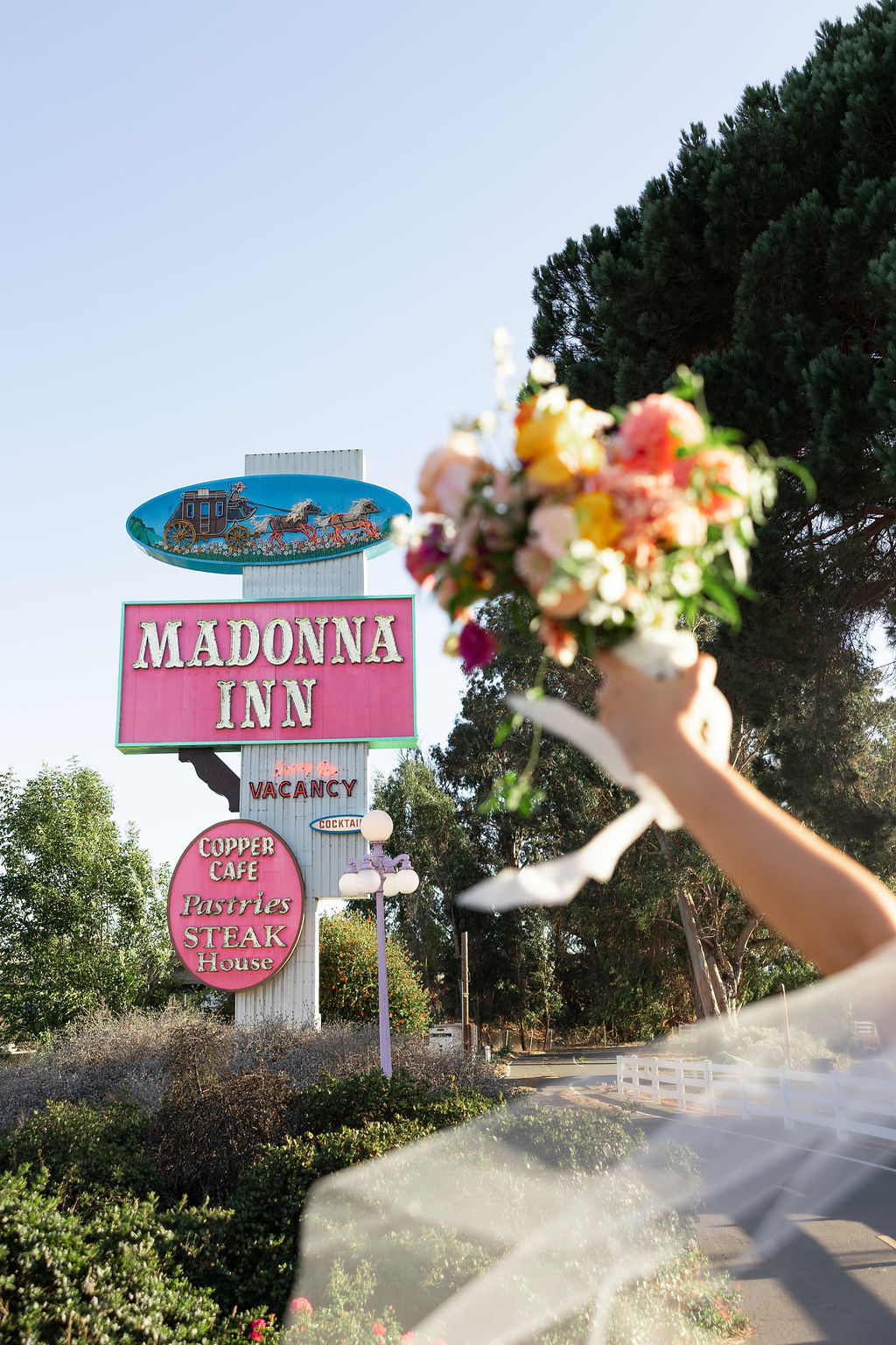 Details of the Madonna Inn wedding venue sign with bride's bouquet