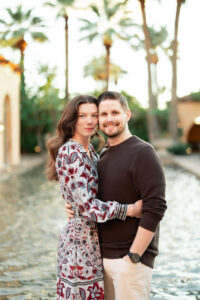 Couple embraces for the engagement portraits surrounded by greenery 