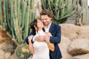 Couple eskimo kisses and hugs tightly for the engagement photos