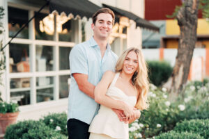 Couple embraces for the engagement portraits surrounded by greenery 