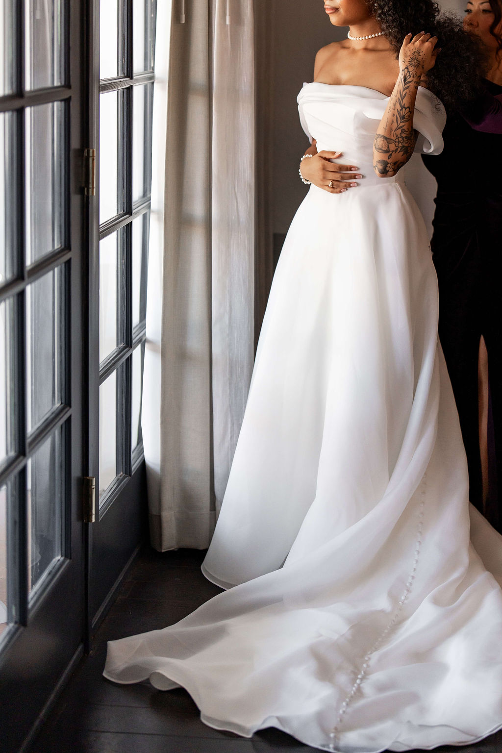 A bride stands in french doors looking out in her gown at the scott resort wedding venue