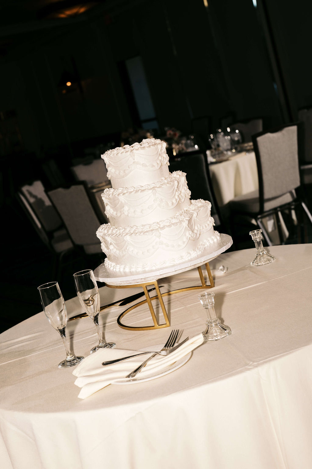Details of a three tier cake on a white linen covered table