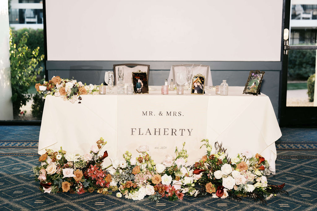 Details of a reception head table set up with lots of colorful flowers at the scott resort wedding venue
