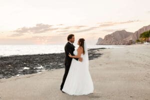 Couple embraces face to face on the beach in Cabo San Lucas for their bridal portraits