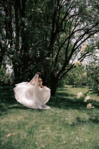 Bride runs around with her dress trailing behind in a deeply wooded area in Rochester 